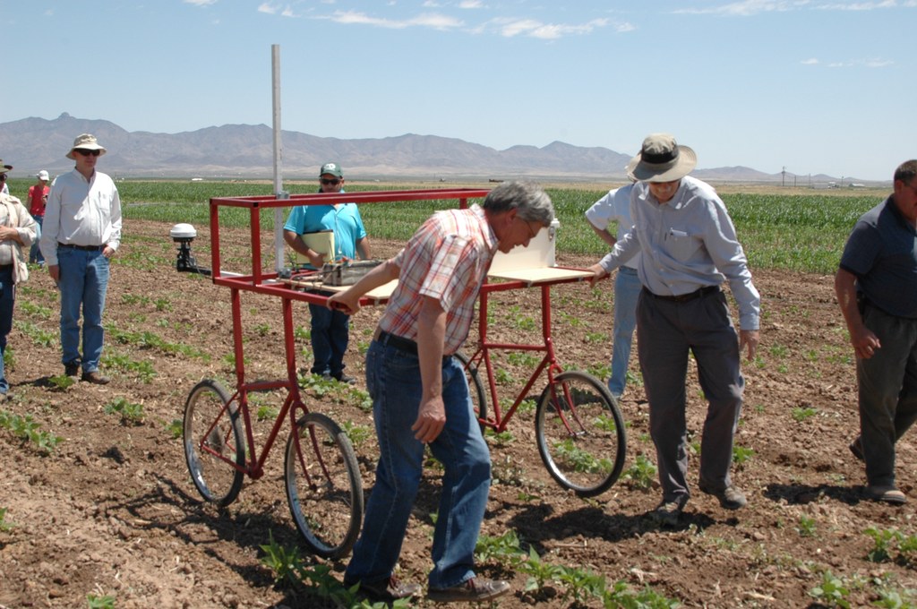 Dr. Jeff White and Dr. Steve Beebe pull the proximal sensing cart through bean fields to demonstrate measurement of canopy temperature, height, and other variables.